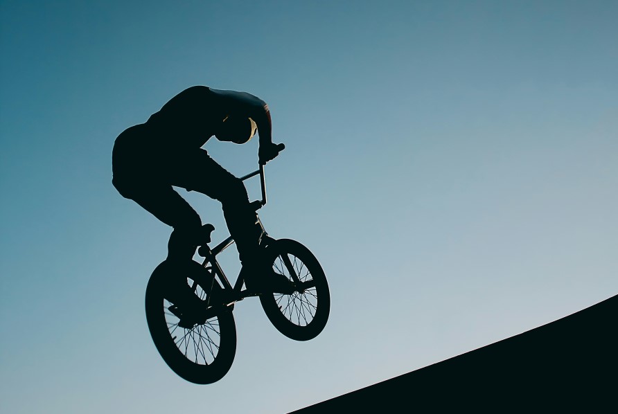 BMX-cyklist som hoppar på ett hinder