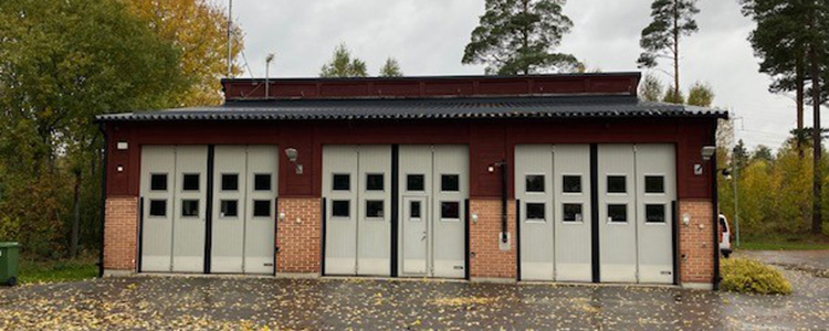 Järlåsa brandstation - en gul och brun byggnad med vita garageportar.