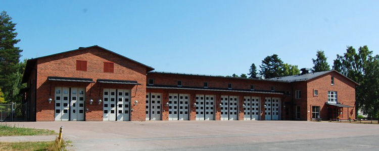 Rosendals brandstation - en byggnad i rött tegel med vita garageportar.
