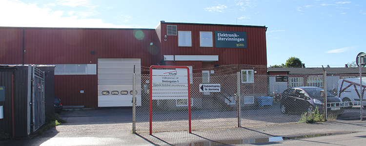 Skebogatan 5, en röd byggnad med stängsel framför