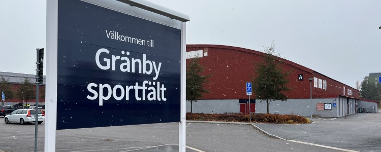 Skylt "Välkommen till Gränby sportfält", Ishall A i bakgrunden